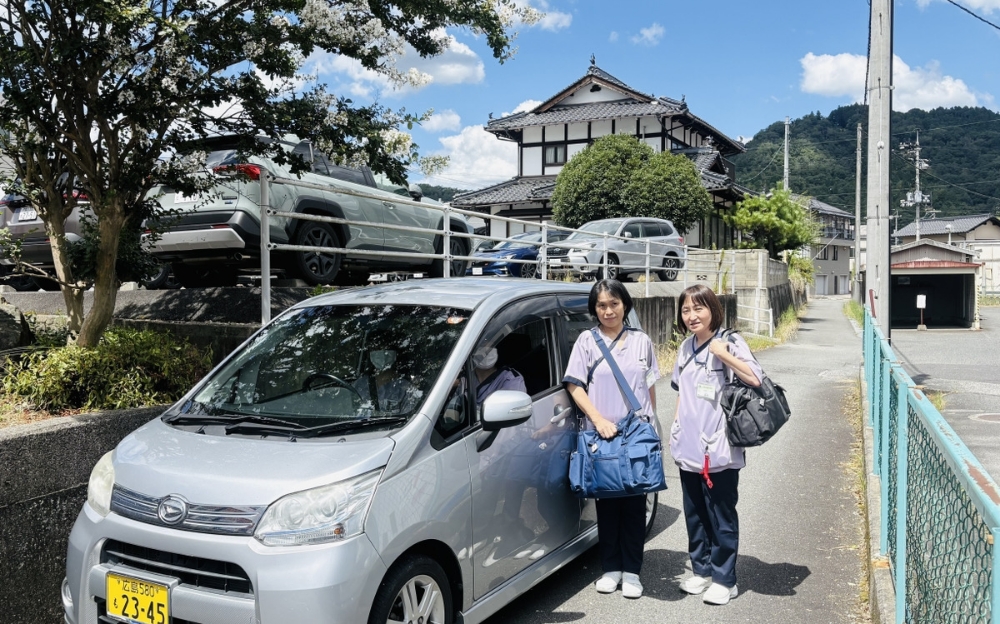 公用車とスタッフの写真